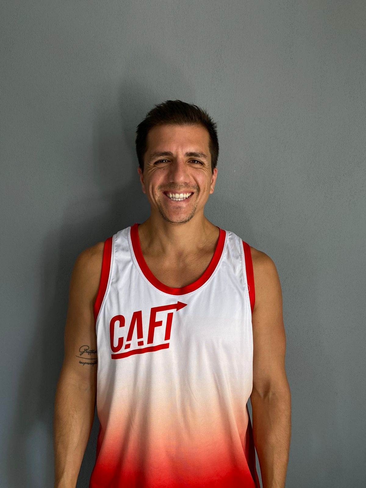 Jorge Mario Alpízar, fundador de CAFI, sonriendo con la camiseta de CAFI